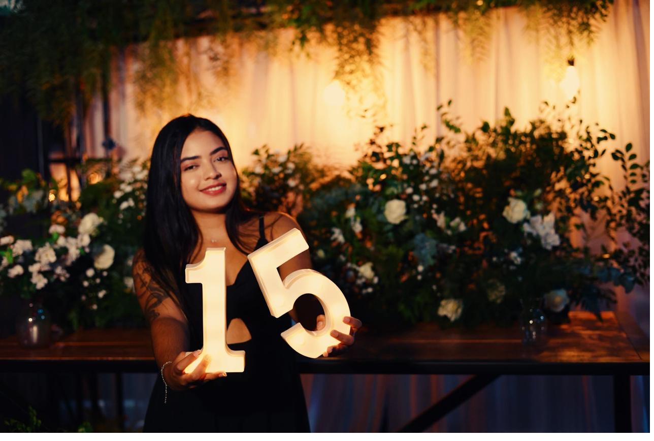 Debutante segurando o número 15 iluminado no Love Haus Campinas